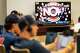 The MLB network plays as Bennett School students work on laptops during a high school sports academy baseball game in Houston, Wednesday, March 25, 2026.