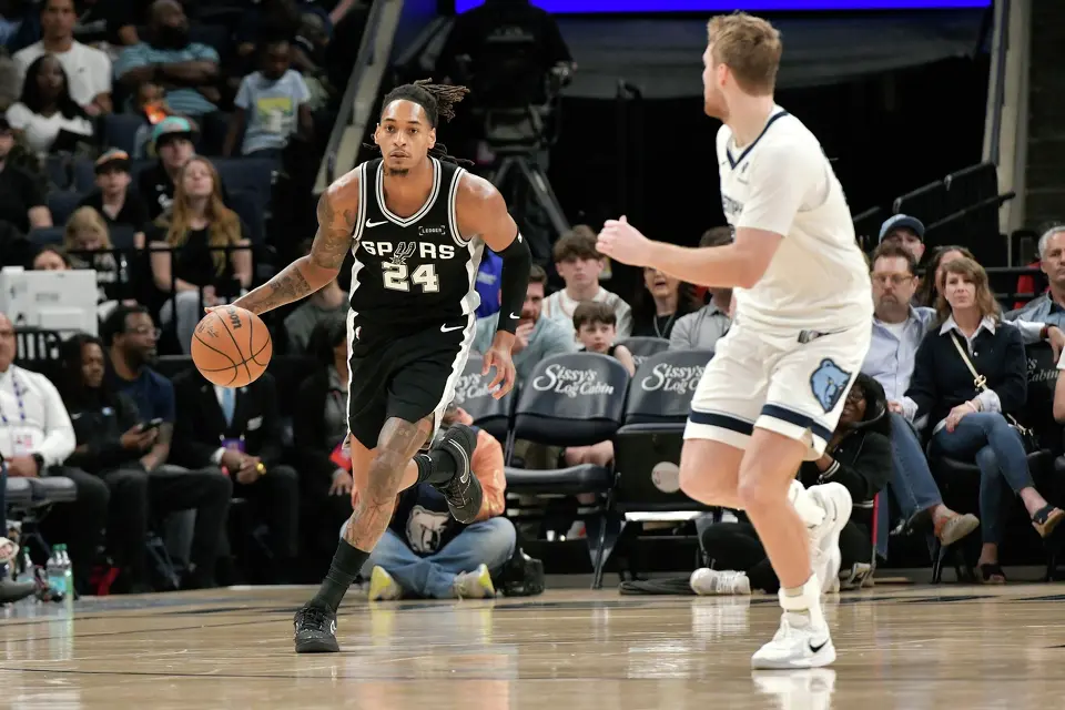San Antonio Spurs guard Devin Vassell (24) brings the ball up court against Memphis Grizzlies guard Cam Spencer, right, in the second half of an NBA basketball game Wednesday, March 25, 2026, in Memphis, Tenn. (AP Photo/Brandon Dill)