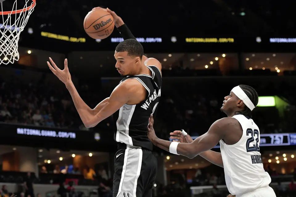 San Antonio Spurs center Victor Wembanyama, left, grabs a rebound against Memphis Grizzlies forward Taylor Hendricks (22) in the first half of an NBA basketball game Wednesday, March 25, 2026, in Memphis, Tenn. (AP Photo/Brandon Dill)