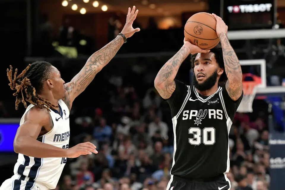 San Antonio Spurs forward Julian Champagnie (30) shoots against Memphis Grizzlies guard Javon Small (10) in the second half of an NBA basketball game Wednesday, March 25, 2026, in Memphis, Tenn. (AP Photo/Brandon Dill)