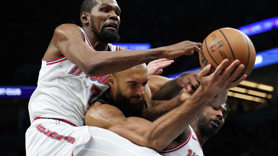 Houston Rockets forward Kevin Durant (7), Minnesota Timberwolves center Rudy Gobert, center, and Houston Rockets guard Amen Thompson, right, compete for a rebound during the first half of an NBA basketball game, Wednesday, March 25, 2026, in Minneapolis. (AP Photo/Ellen Schmidt)