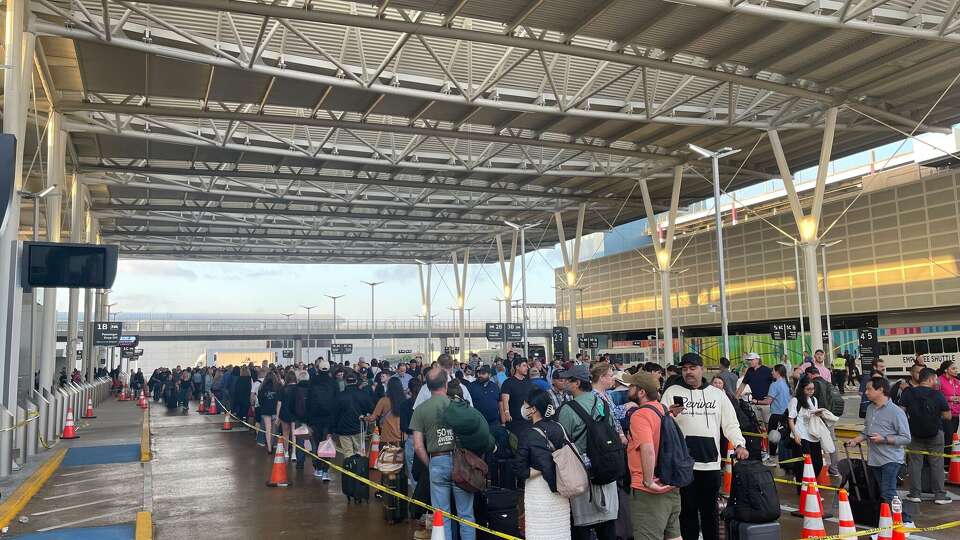 A TSA standard screening line spilled outside at Houston's George Bush Intercontinental Airport on Thursday, March 26, 2026.