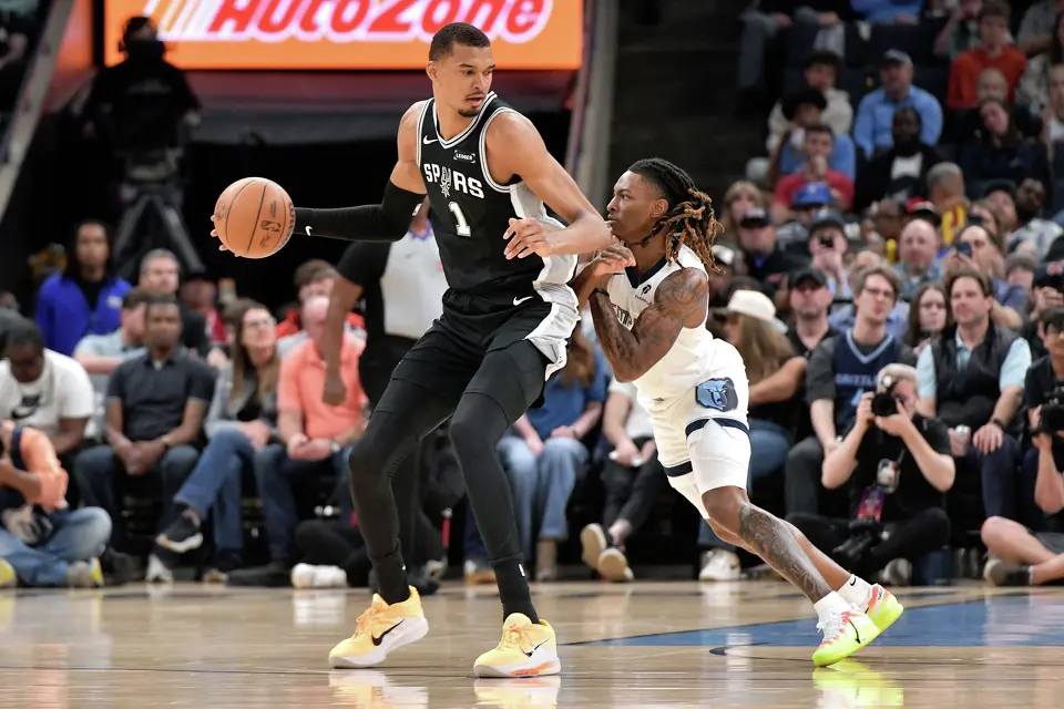 San Antonio Spurs forward Victor Wembanyama (1) handles the ball against Memphis Grizzlies guard Javon Small, right, in the first half of an NBA basketball game Wednesday, March 25, 2026, in Memphis, Tenn. (AP Photo/Brandon Dill)