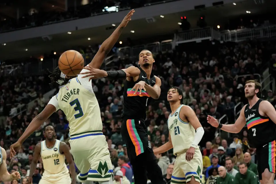 San Antonio Spurs' Victor Wembanyama passes the ball around Milwaukee Bucks' Myles Turner during the second half of an NBA basketball game Saturday, March 28, 2026, in Milwaukee. (AP Photo/Aaron Gash)