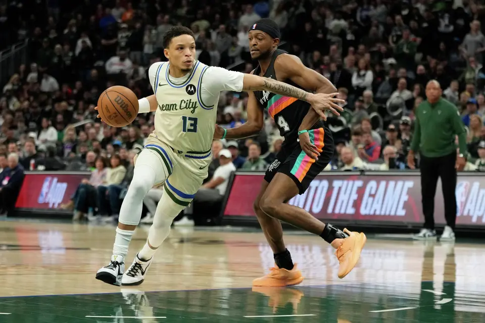 Milwaukee Bucks' Ryan Rollins (13) drives to the basket against San Antonio Spurs' De'Aaron Fox during the first half of an NBA basketball game Saturday, March 28, 2026, in Milwaukee. (AP Photo/Aaron Gash)