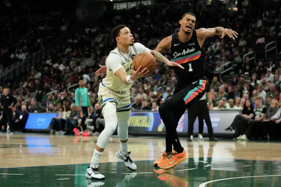 Milwaukee Bucks' Ryan Rollins, left, shoots against San Antonio Spurs' Victor Wembanyama during the first half of an NBA basketball game Saturday, March 28, 2026, in Milwaukee. (AP Photo/Aaron Gash)