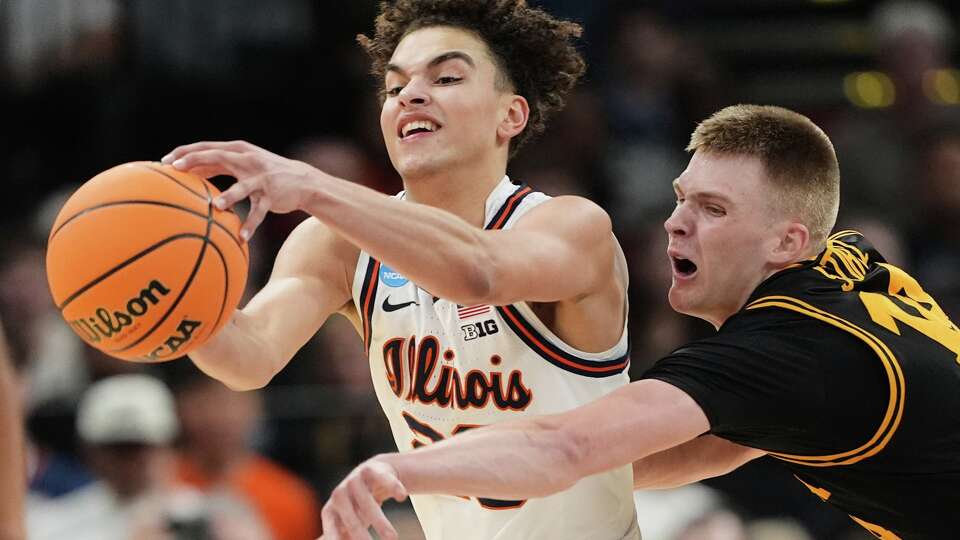 Iowa's Kael Combs (11) reaches to knock the ball away from Illinois' Keaton Wagler during the first half of an Elite Eight game in the NCAA college basketball tournament Saturday, March 28, 2026, in Houston. (AP Photo/Eric Gay)