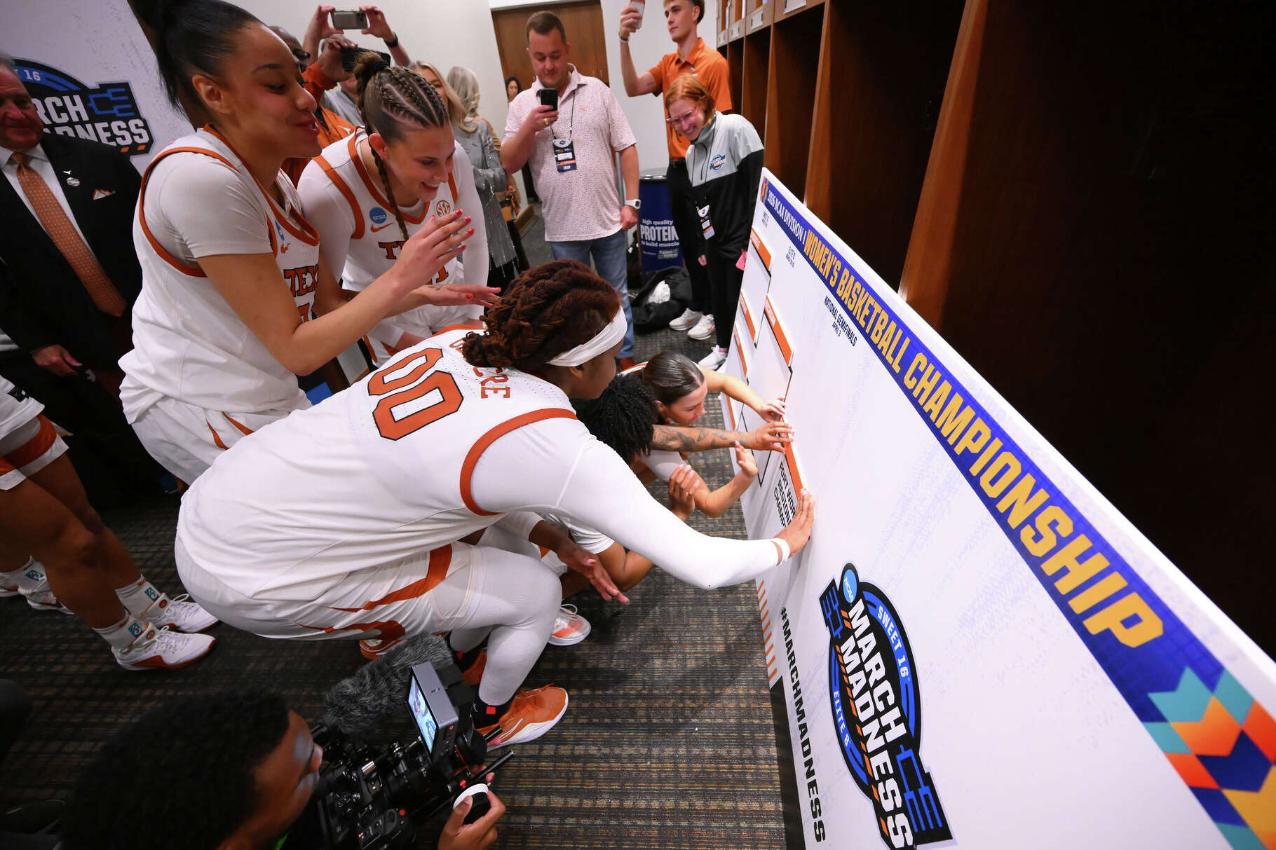 Texas Longhorns players place their name in the bracket after defeating the Kentucky Wildcats in the Sweet 16 of the NCAA Tournament on March 28, 2026 at Dickies Arena in Fort Worth.