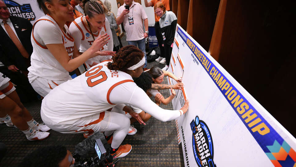 Texas Longhorns players place their name in the bracket after defeating the Kentucky Wildcats in the Sweet 16 of the NCAA Tournament on March 28, 2026 at Dickies Arena in Fort Worth.