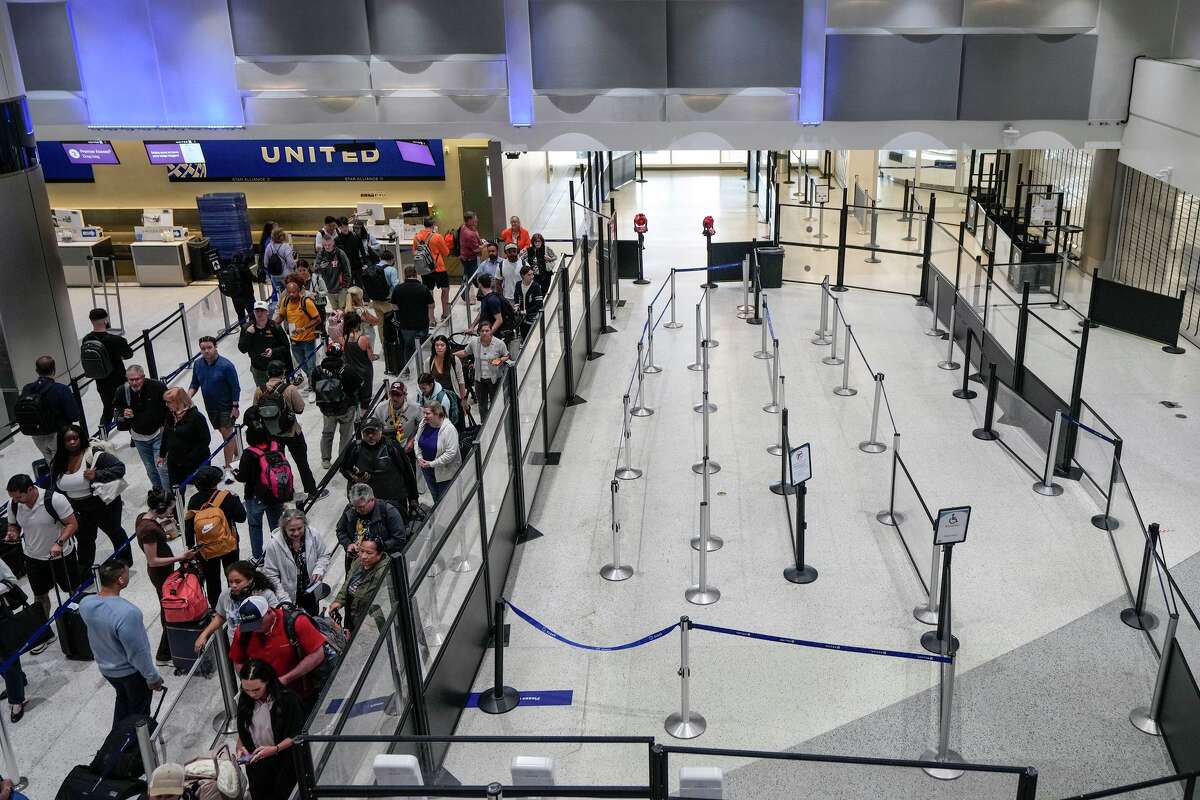 Airline passengers make their way through the security lines, next to a closed screening area, in Terminal C at George Bush Intercontinental Airport in Houston, Sunday, March 29, 2026.