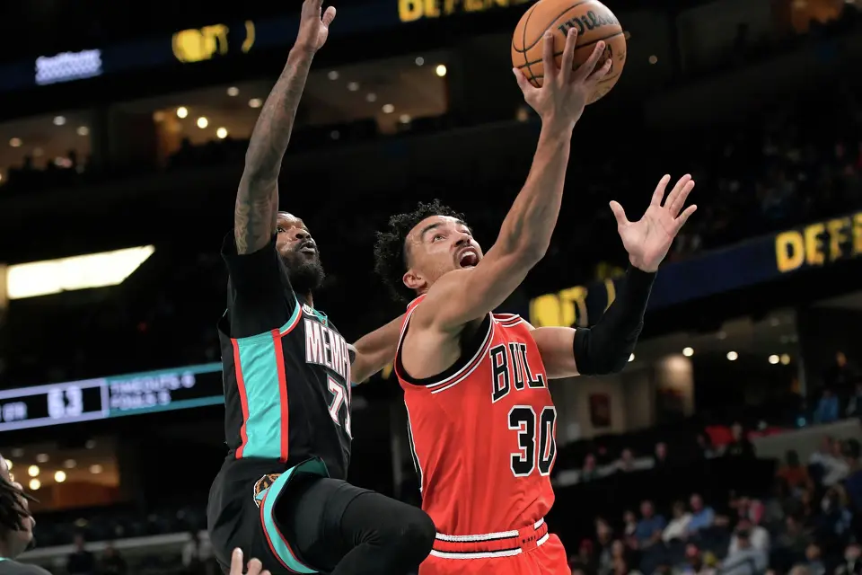 Chicago Bulls guard Tre Jones (30) shoots ahead of Memphis Grizzlies guard DeJon Jarreau (77) in the first half of an NBA basketball game Saturday, March 28, 2026, in Memphis, Tenn. (AP Photo/Brandon Dill)