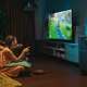 A child and grandfather playing a video game on a TV powered by a Jackery Home Generator.