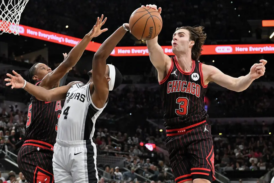 Chicago Bulls guard Josh Giddey (3) blocks a shot-attempt by San Antonio Spurs guard De'Aaron Fox (4) during the first half of an NBA basketball game, Monday, March 30, 2026, in San Antonio. (AP Photo/Darren Abate)