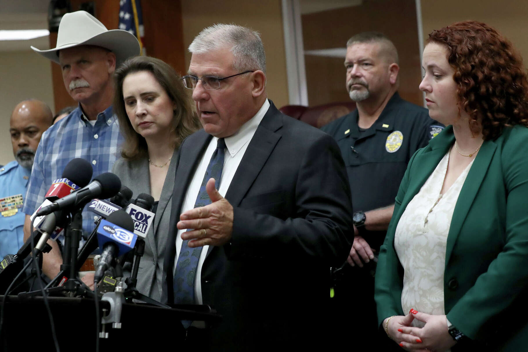 Galveston County District Attorney Kenneth Cusick, center, flanked by law enforcement officers from across the county and Assistant District Attorney Kate Willis, right, the violence against women chief, talks Wednesday, April 1, 2026, about the grand jury indictment against James Dolphs Elmore Jr. for manslaughter and two charges of tampering with evidence in connection with the deaths of Laura Miller and Audrey Cook.
