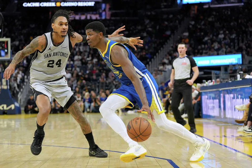 Golden State Warriors guard Nate Williams (19) drives past San Antonio Spurs guard Devin Vassell (24) during the second half of an NBA basketball game in San Francisco, Wednesday, April 1, 2026. (AP Photo/Tony Avelar)