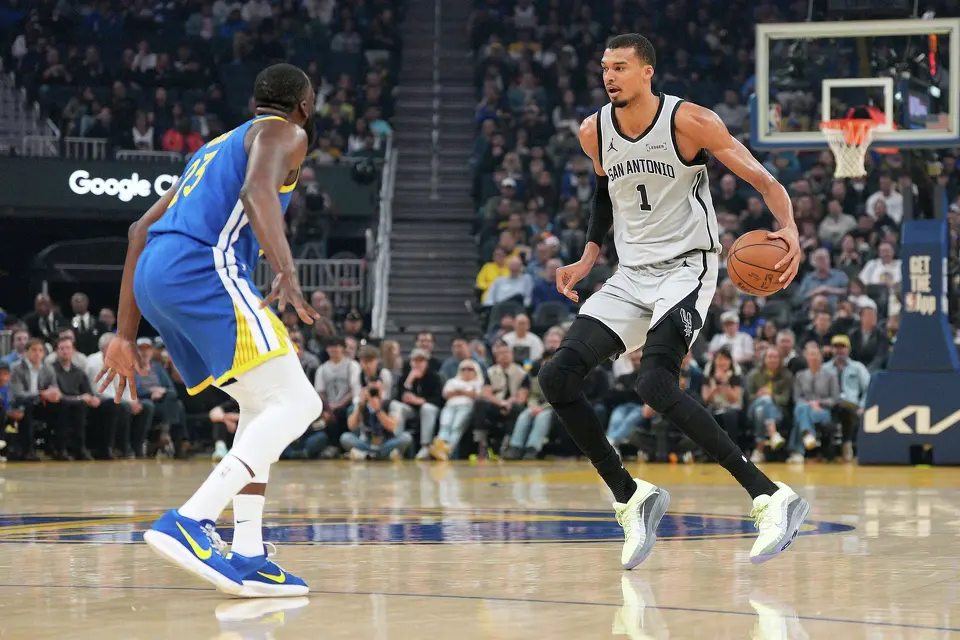 San Antonio Spurs forward Victor Wembanyama (1) dribbles down the court against Golden State Warriors forward Draymond Green (23) during the first half of an NBA basketball game in San Francisco, Wednesday, April 1, 2026. (AP Photo/Tony Avelar)