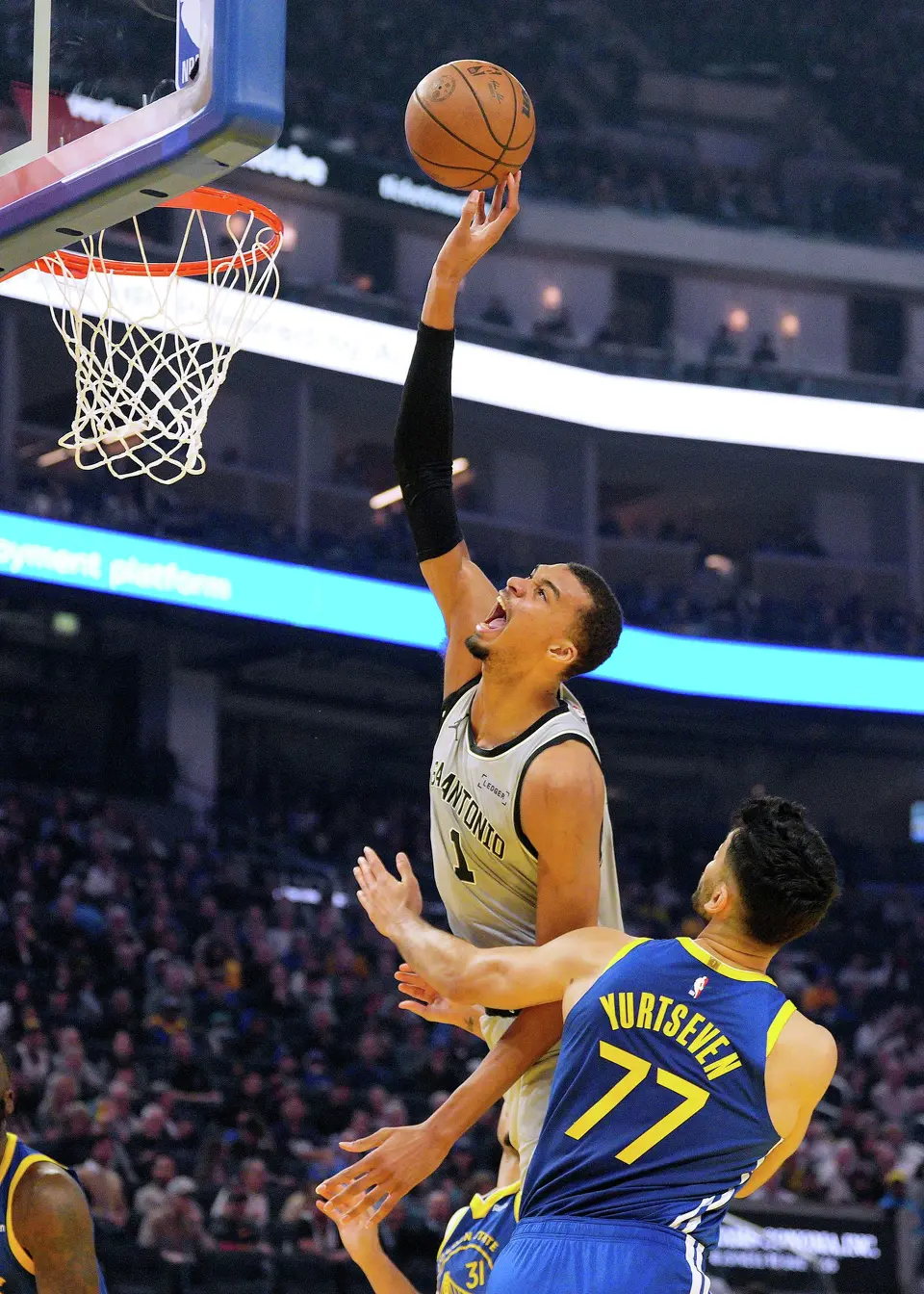 San Antonio Spurs forward Victor Wembanyama (1) reacts as he is fouled by Golden State Warriors center Omer Yurtseven (77) during the first half of an NBA basketball game in San Francisco, Wednesday, April 1, 2026. (AP Photo/Tony Avelar)