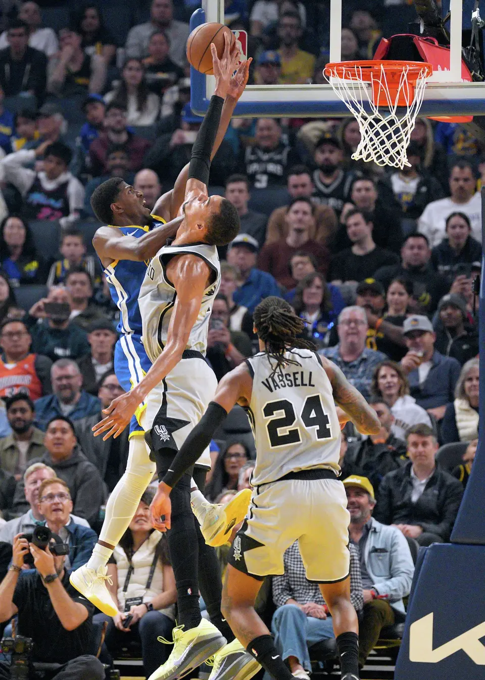 San Antonio Spurs forward Victor Wembanyama, center, blocks a shot against Golden State Warriors guard Nate Williams, left, as Devin Vassell (24) looks on during the first half of an NBA basketball game in San Francisco, Wednesday, April 1, 2026. (AP Photo/Tony Avelar)