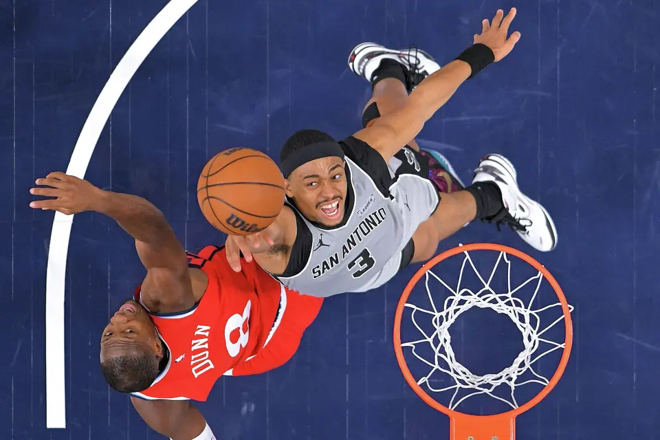 Los Angeles Clippers guard Kris Dunn, left, and San Antonio Spurs forward Keldon Johnson go after a rebound during the second half of an NBA basketball game Thursday, April 2, 2026, in Inglewood, Calif. (AP Photo/Mark J. Terrill)