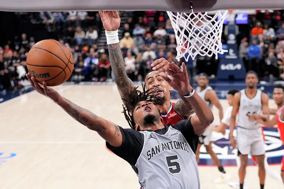 San Antonio Spurs guard Stephon Castle, below, shoots as Los Angeles Clippers forward John Collins defends during the second half of an NBA basketball game Thursday, April 2, 2026, in Inglewood, Calif. (AP Photo/Mark J. Terrill)