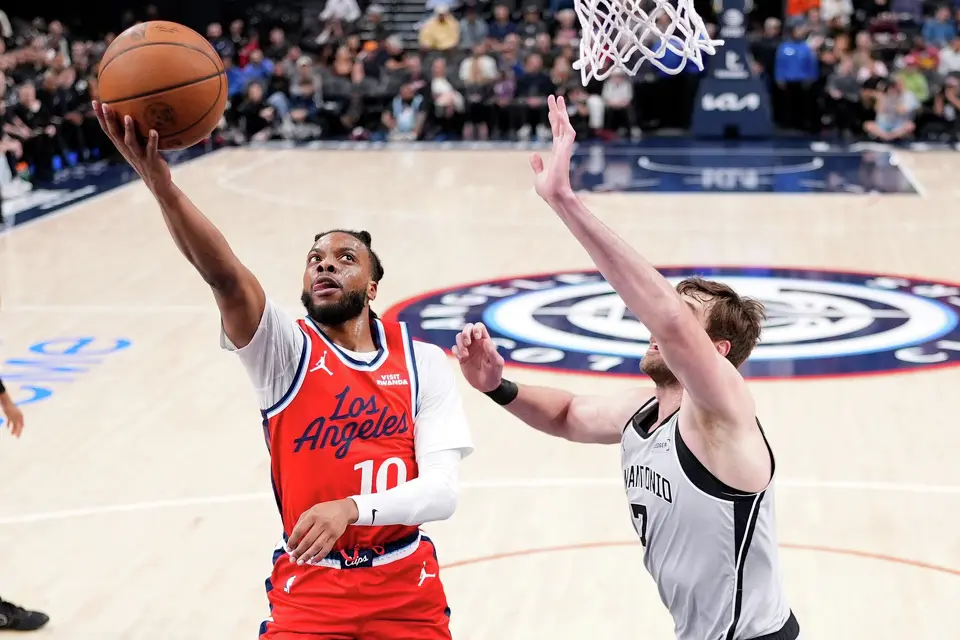 Los Angeles Clippers guard Darius Garland, left, shoots as San Antonio Spurs center Luke Kornet defends during the first half of an NBA basketball game Thursday, April 2, 2026, in Inglewood, Calif. (AP Photo/Mark J. Terrill)