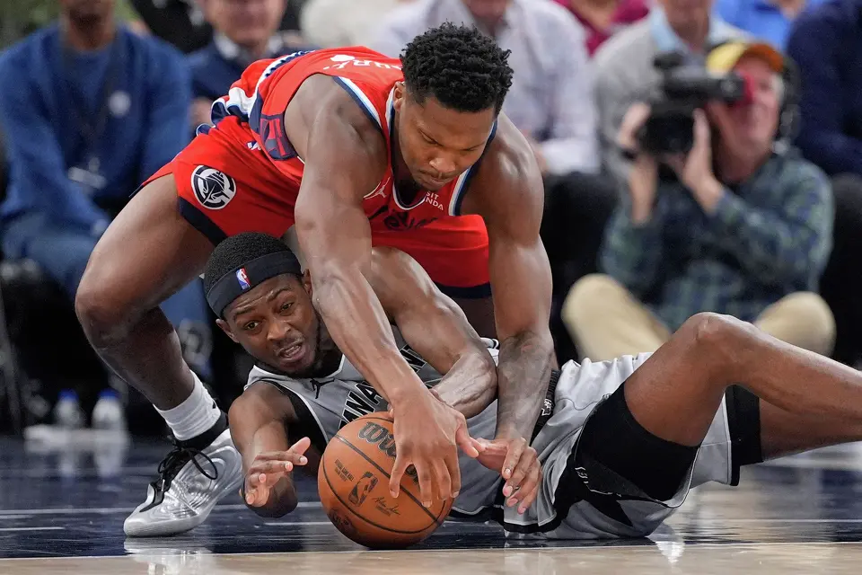 Los Angeles Clippers guard Bennedict Mathurin, top, and San Antonio Spurs guard De'aaron Fox scramble for a loose ball during the second half of an NBA basketball game Thursday, April 2, 2026, in Inglewood, Calif. (AP Photo/Mark J. Terrill)
