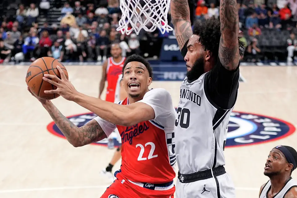 Los Angeles Clippers guard Jordan Miller, left, shoots as San Antonio Spurs forward Julian Champagnie defends during the first half of an NBA basketball game Thursday, April 2, 2026, in Inglewood, Calif. (AP Photo/Mark J. Terrill)