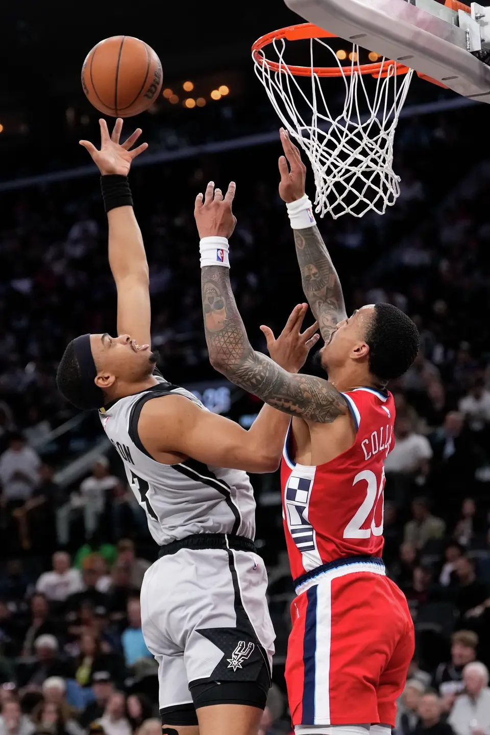 San Antonio Spurs forward Keldon Johnson, left, shoots as Los Angeles Clippers forward John Collins defends during the first half of an NBA basketball game Thursday, April 2, 2026, in Inglewood, Calif. (AP Photo/Mark J. Terrill)