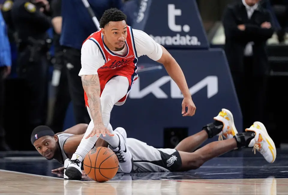 Los Angeles Clippers guard Jordan Miller, top, takes a loose ball away from San Antonio Spurs guard De'aaron Fox during the second half of an NBA basketball game Thursday, April 2, 2026, in Inglewood, Calif. (AP Photo/Mark J. Terrill)