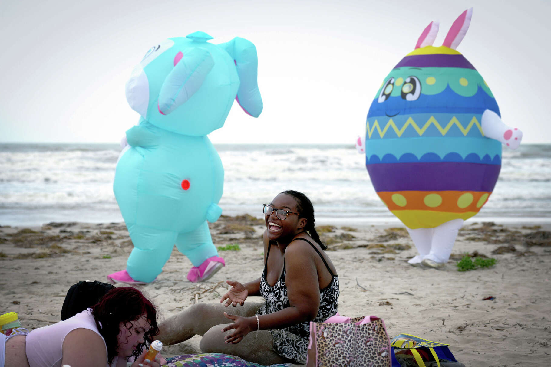 Keairys Wells of Texas City laughs as Jorge Rodriguez of Pearland, dressed as the Easter Bunny, and Andrea Marroquin of Jacinto City, dressed as an Easter egg, surprise her on the beach in Galveston, Texas, on April 3, 2026. Bea and Jorge Rodriguez began the tradition in 2020 during the pandemic to spread joy and have continued it each year since.