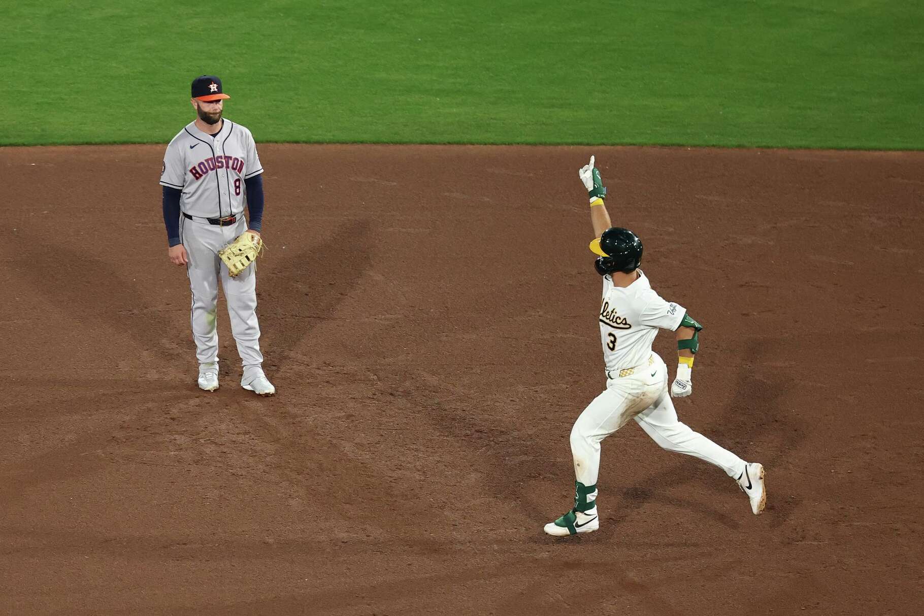 Athletics' Max Muncy (3) runs past Houston Astros first baseman Christian Walker (8) after hitting a home run during the fourth inning of a home-opener baseball game Friday, April 3, 2026, in West Sacramento, Calif. (AP Photo/Sara Nevis)