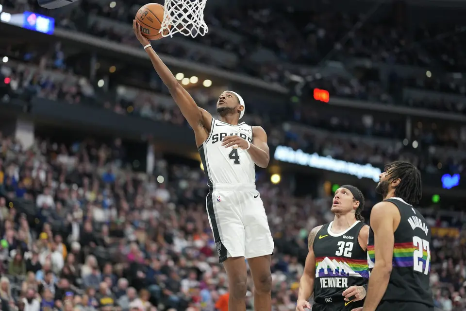 San Antonio Spurs guard De'aaron Fox, left, drives to the rim past Denver Nuggets guard Jamal Murray, front right, and forward Aaron Gordon in the first half of an NBA basketball game Saturday, April 4, 2026, in Denver. (AP Photo/David Zalubowski)