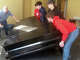 Craig Boyd of Boyd Music and members of the Jacksonville High School football team lift a piano inside MacMurray Hall. The piano was one of those used by The Esprit de Corps Academy being moved to the academy's new facility in the former Grace United Methodist Church building.