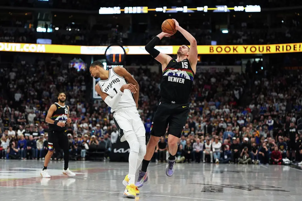 San Antonio Spurs center Victor Wembanyama, left, reels back after getting hit by Denver Nuggets center Nikola Jokic as he went up for a shot in overtime of an NBA basketball game Saturday, April 4, 2026, in Denver. (AP Photo/David Zalubowski)