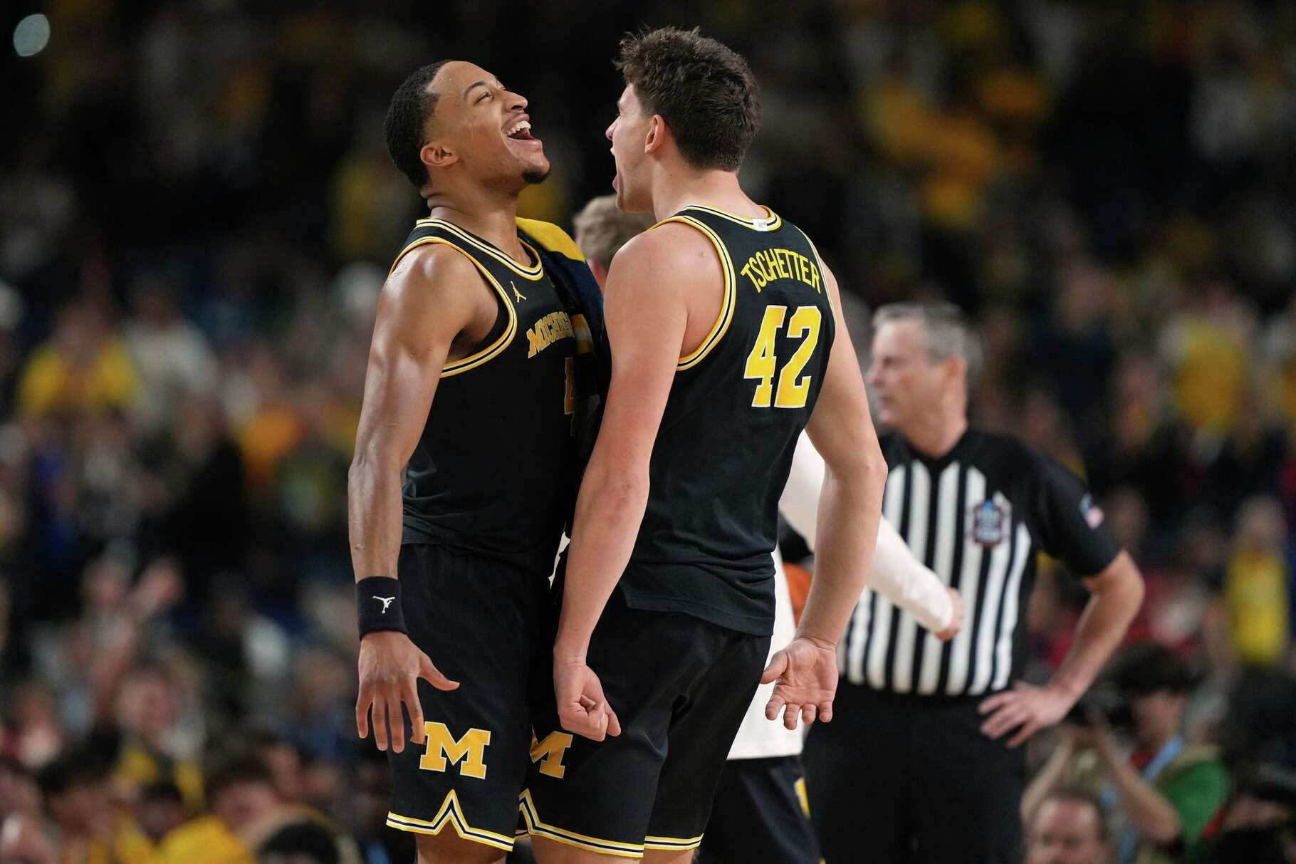 Michigan's Nimari Burnett, left, and Will Tschetter (42) celebrate during the second half of an NCAA college basketball tournament semifinal game against Arizona at the Final Four, Saturday, April 4, 2026, in Indianapolis.