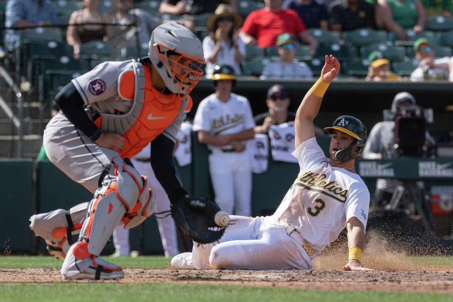 Houston Astros catcher Yainer Diaz (21) attempts to get Athletics' Max Muncy (3) out at home during the seventh inning of a baseball game Sunday, April 5, 2026, in West Sacramento, Calif. (AP Photo/Sara Nevis)