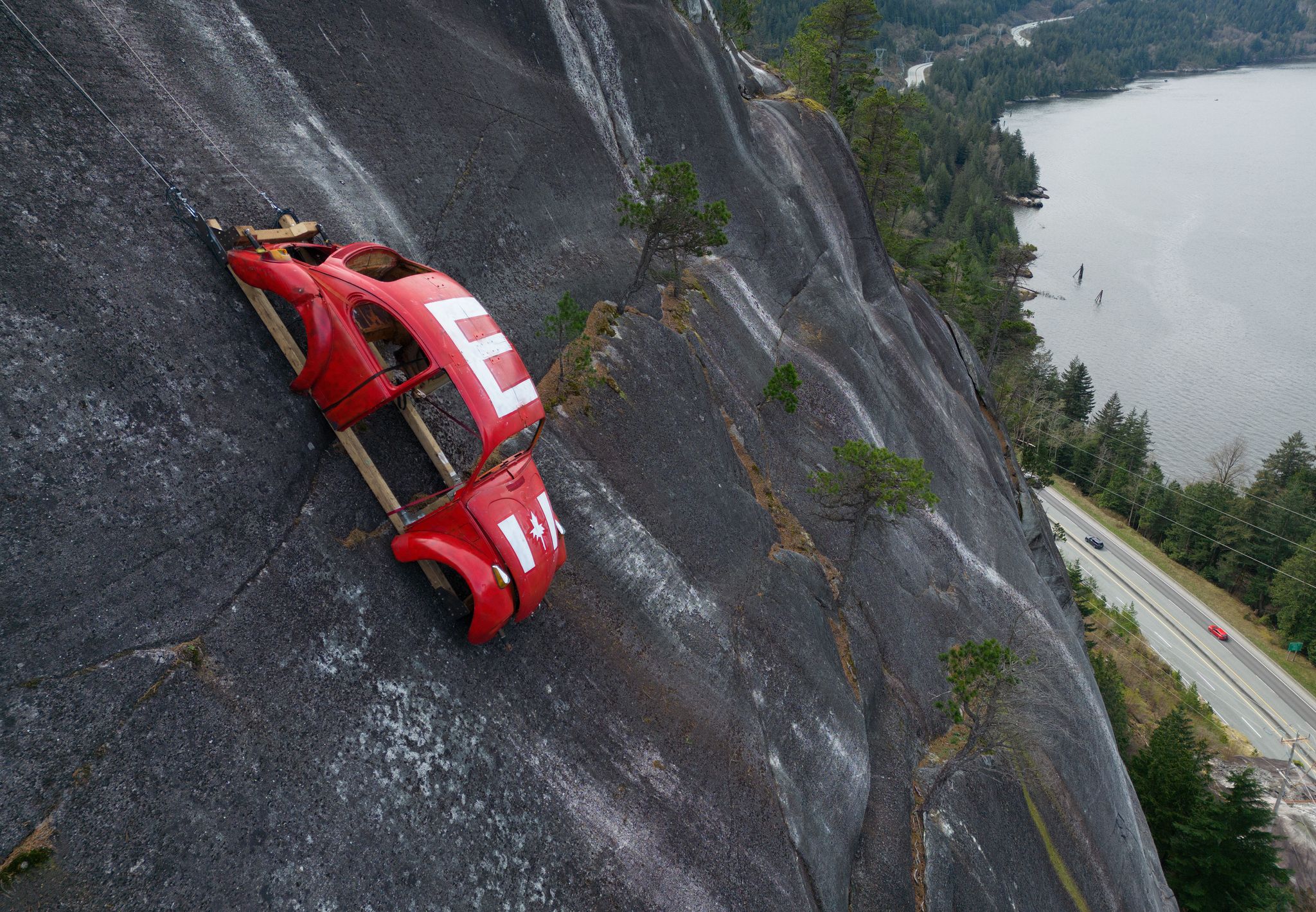 Car shell suspended on rock face above British Columbia highway in ...