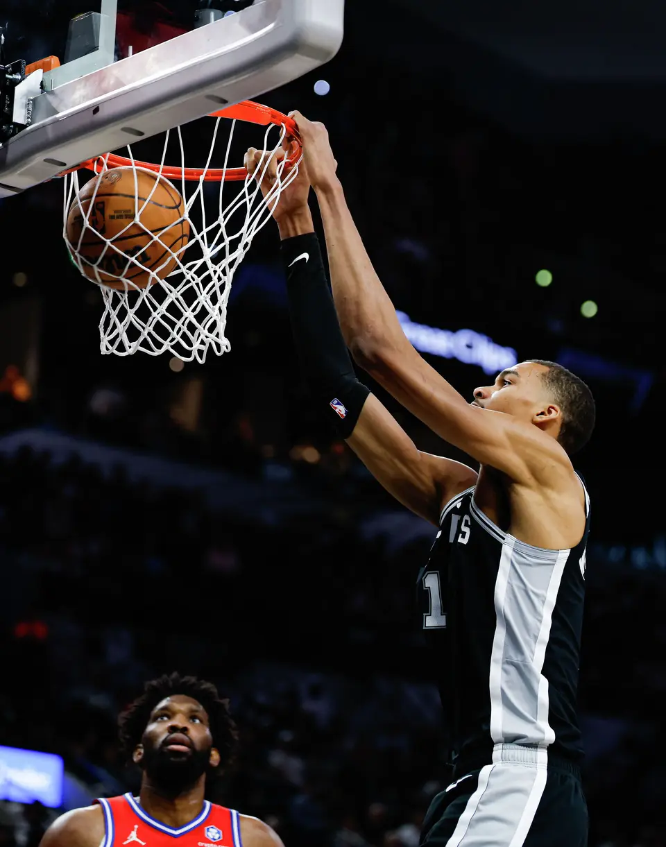 San Antonio Spurs forward Victor Wembanyama (1) dunks over /Philadelphia 76ers center Joel Embiid (21) during an NBA game at Frost Bank Center in San Antonio, Monday, April 6, 2026.
