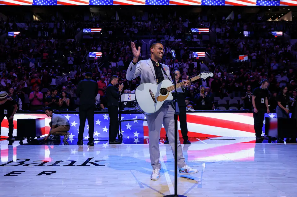Jacob Tobey waves to a cheering crowd after singing the National Anthem on Native American Heritage Night before a game between the San Antonio Spurs and the Philadelphia 76ers at Frost Bank Center in San Antonio, Monday, April 6, 2026.