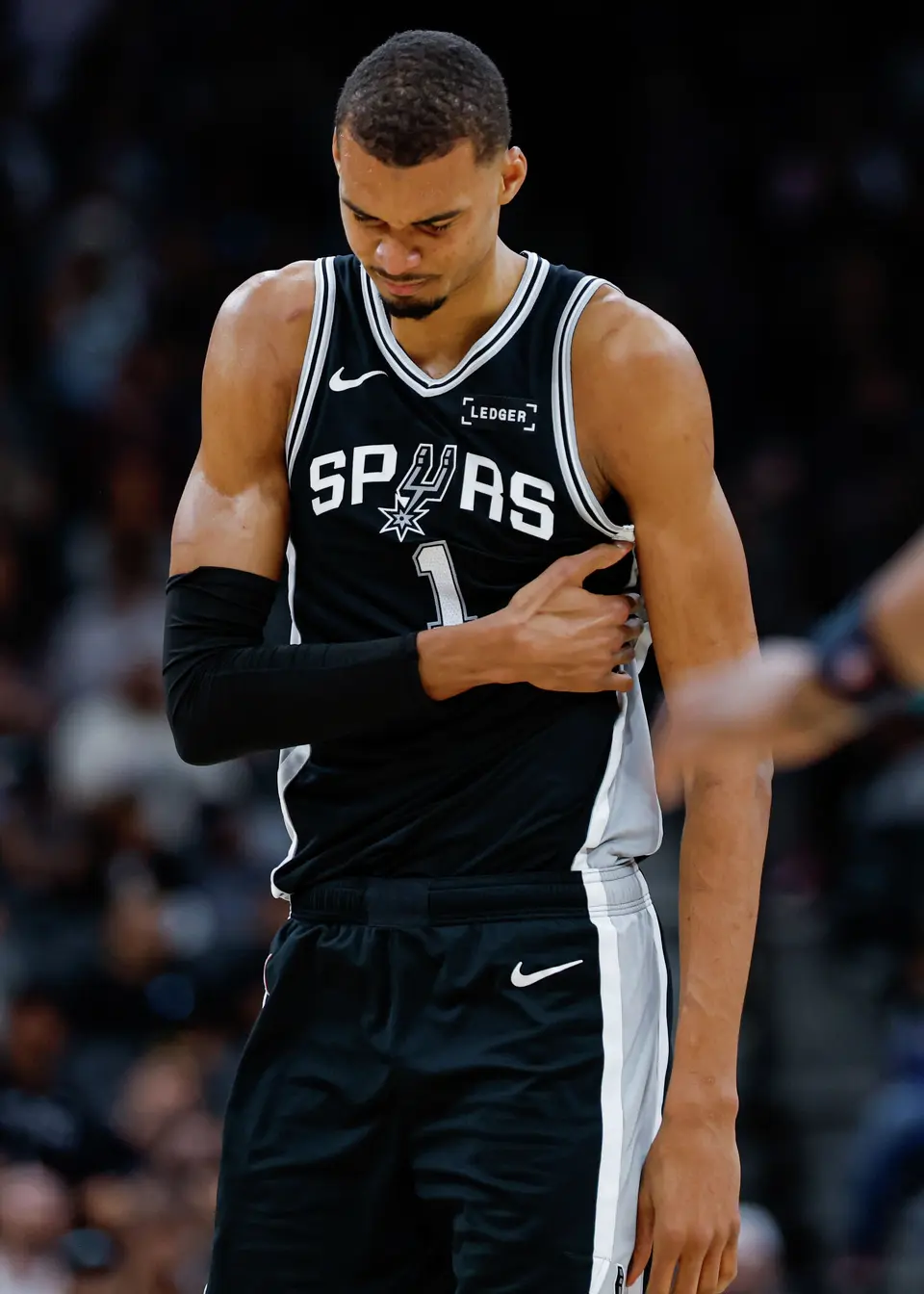 San Antonio Spurs forward Victor Wembanyama (1) grabs his left side following a collision with Philadelphia 76ers forward Paul George (8) during the second quarter at Frost Bank Center in San Antonio, Monday, April 6, 2026. He sat out in the second half due to a left rib contusion.