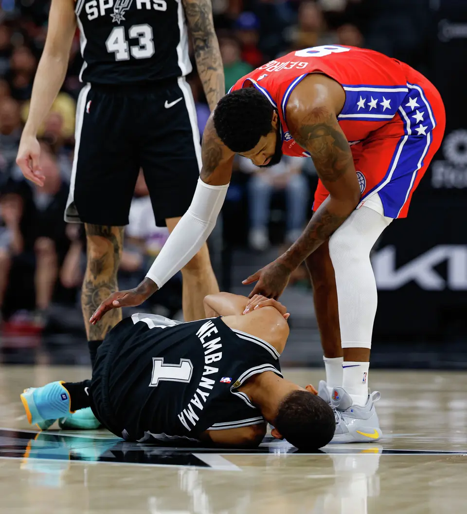 Philadelphia 76ers forward Paul George (8) checks on San Antonio Spurs forward Victor Wembanyama (1) following their collision during the second quarter at Frost Bank Center in San Antonio, Monday, April 6, 2026. Wembanyama sat out in the second half due to a left rib contusion.