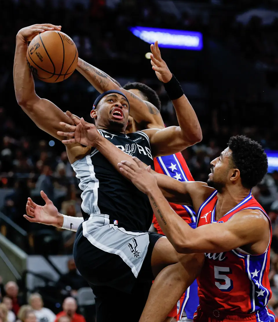 San Antonio Spurs forward Keldon Johnson (3) is fouled while shooting over Philadelphia 76ers forward Dominick Barlow (25) and guard Quentin Grimes (5) during an NBA game at Frost Bank Center in San Antonio on Monday, April 6, 2026. The Spurs won 115-102.