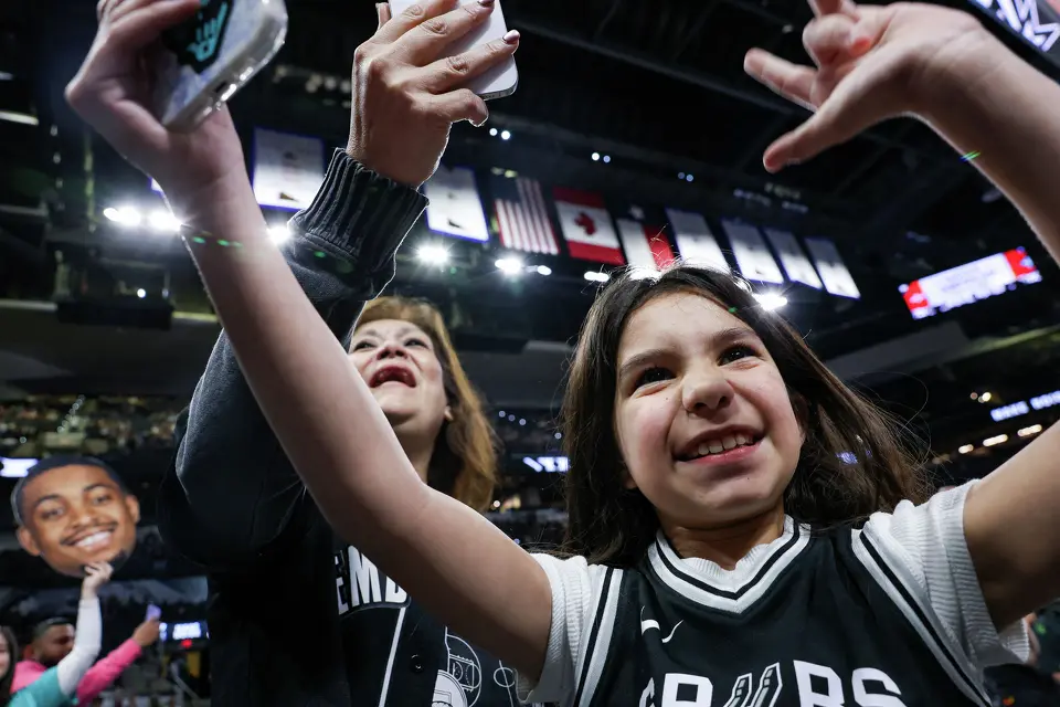 Olivia Aguilar, 10, and her grandmother, Bianca Contreras, cheer as the San Antonio Spurs run onto the court for warmups before an NBA game against the Philadelphia 76ers at Frost Bank Center in San Antonio on Monday, April 6, 2026. The Spurs won 115-102.