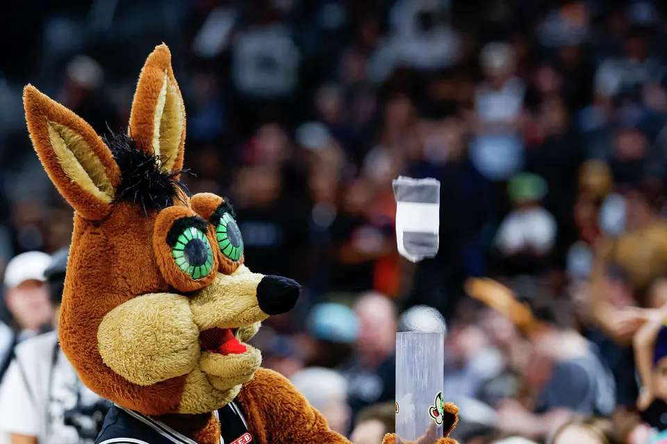 The Spurs’ Coyote launches a free T-shirt into the crowd with a T-shirt cannon during a timeout in the fourth quarter of an NBA game against the Philadelphia 76ers at Frost Bank Center in San Antonio on Monday, April 6, 2026. The Spurs won 115-102.