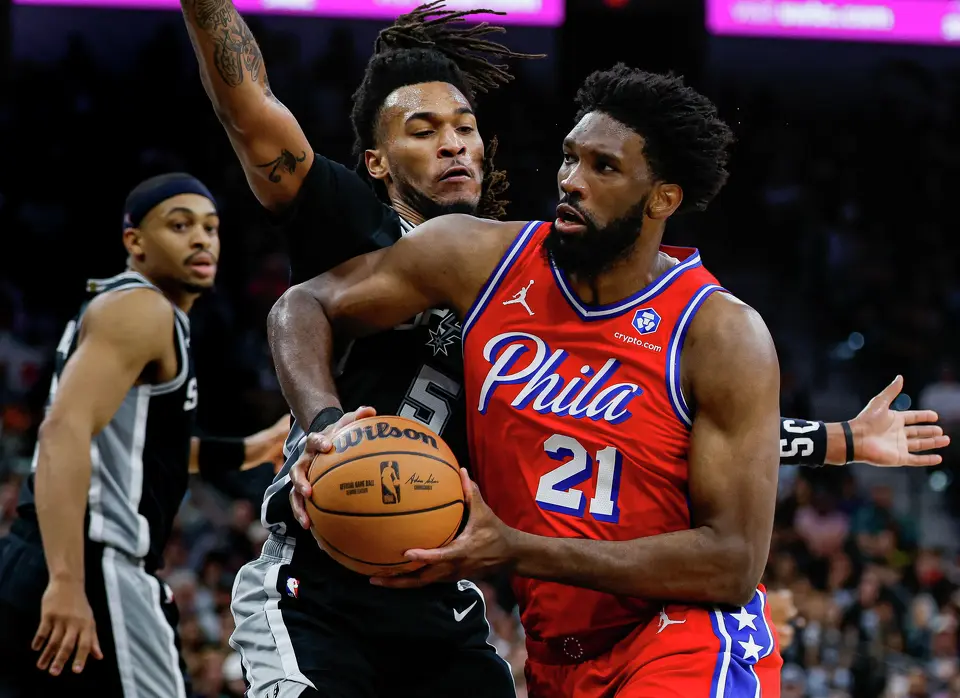 San Antonio Spurs guard Stephon Castle (5) guards Philadelphia 76ers center Joel Embiid (21) as he drives to the net during an NBA game at Frost Bank Center in San Antonio, Monday, April 6, 2026. The Spurs defeated the 76ers 115-102.