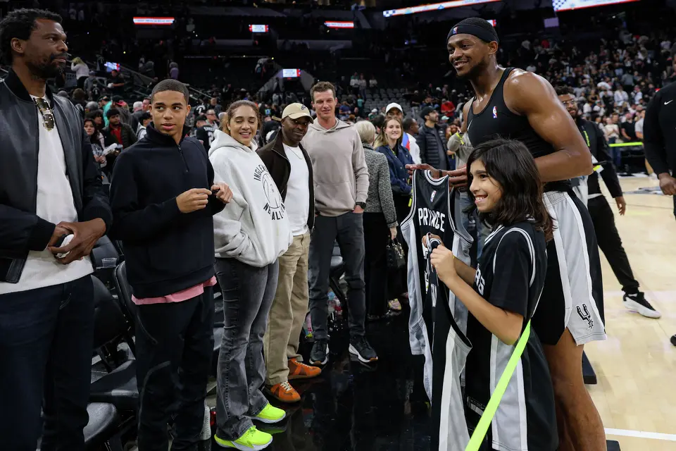 San Antonio Spurs guard De’Aaron Fox (4) poses with Prince Garcia, 11, after signing his jersey following an NBA game against the Philadelphia 76ers at Frost Bank Center in San Antonio on Monday, April 6, 2026. The Spurs won 115-102.