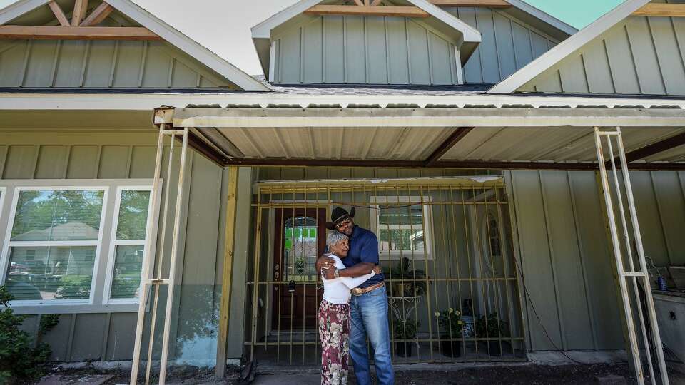 Jean Smith, left, embraces Fred Woods in front of her home, that is being repaired after Hurricane Beryl damaged it, as they met to talk about how Harris County’s new flood maps will affect residents of the Northwood Manor neighborhood in Houston, Tuesday, April 7, 2026. The neighbors are concerned how Harris County's new flood maps and flood insurance requirements will affect their neighborhoods.