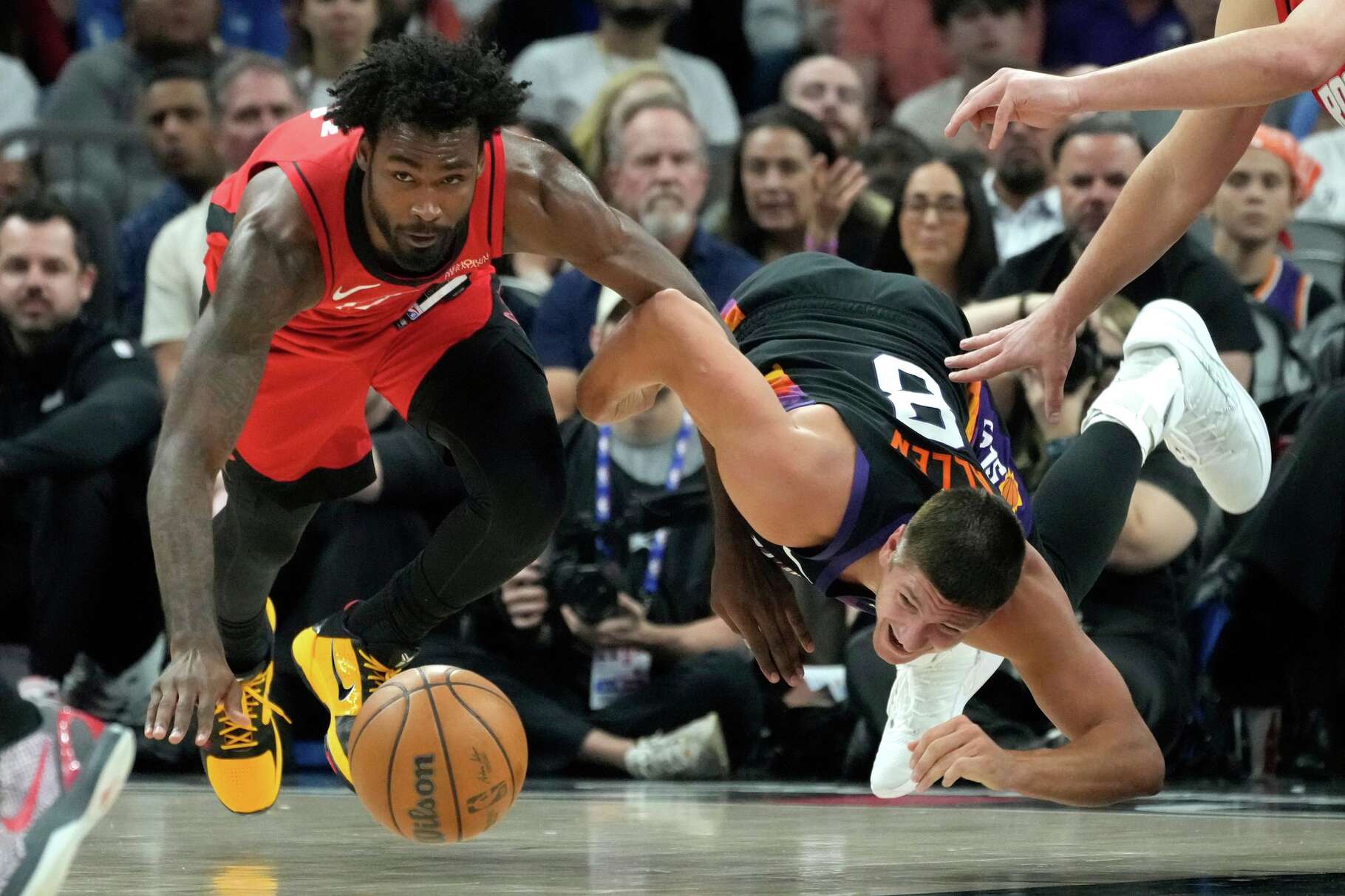 Houston Rockets forward Tari Eason, left, and Phoenix Suns guard Grayson Allen (8) dive after a loose ball during the first half of an NBA basketball game, Tuesday, April 7, 2026, in Phoenix. (AP Photo/Ross D. Franklin)