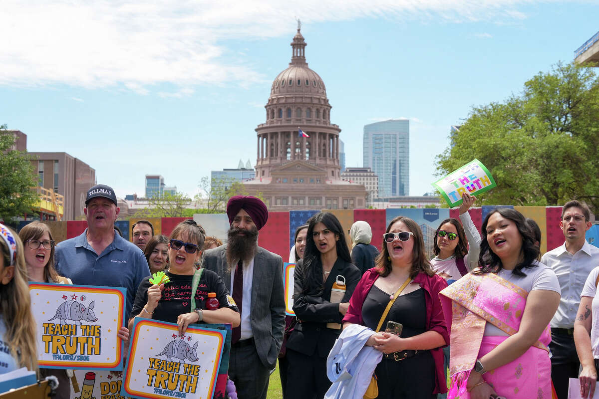 People hold signs reading “Teach the Truth” during a rally on the Capitol Mall outside the Barbara Jordan State Office Building, where the State Board of Education meets, in Austin, Tuesday, April 7, 2026. Parents, educators and community members gathered to oppose proposed changes to the state’s social studies curriculum, known as Texas Essential Knowledge and Skills, or TEKS, as the board considers revisions.