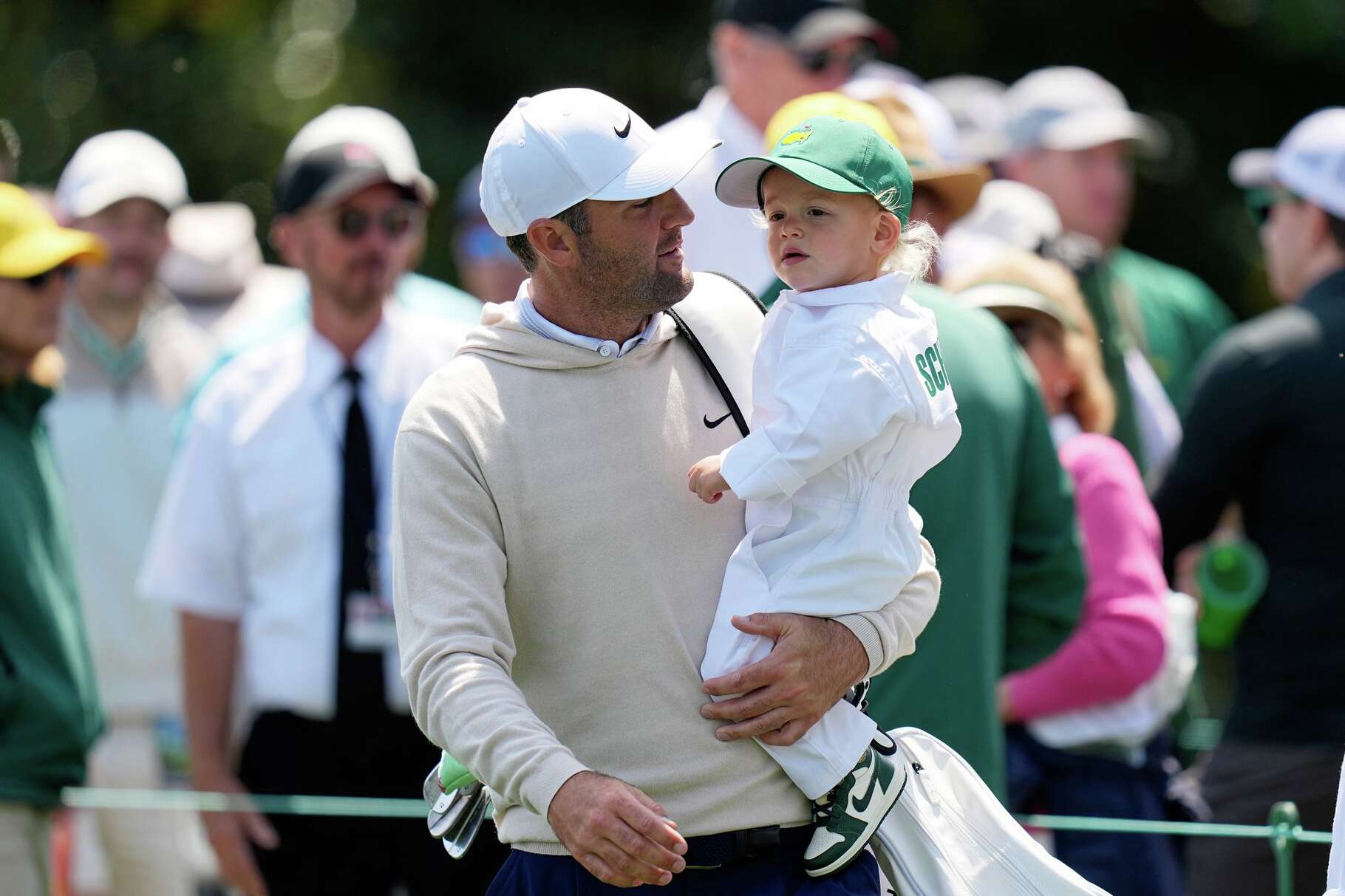 Scottie Scheffler, left, carries his son, Bennett, on the sixth hole during par-3 contest ahead of the Masters golf tournament at the Augusta National Golf Club, Wednesday, April 8, 2026, in Augusta, Ga.